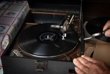 Old vintage turntable vinyl record player with disc spinning and playing music