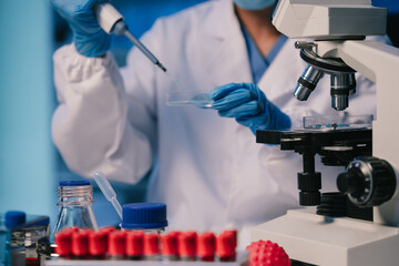 Medical or research scientist or doctor using looking at a test tube of clear solution in a lab or laboratory.