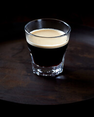 Coffee in glass cup on dark background. Close up. Copy space