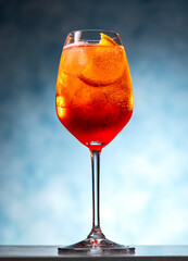 Closeup of aperol spritz cocktail in wineglass on blue background