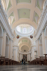 Couple strolling in a grand Urbino cathedral with high ceilings