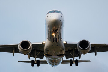 Airplane flying with its wheels extended above the ground