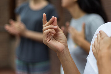 People doing percussion with their bodies. A hand in the foreground making a clicking sound