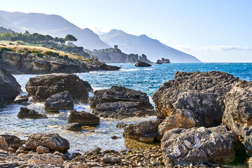 Rocky shore in Sicily surrounded by mountains