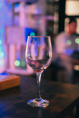 Wine glass on a table with lights in the background