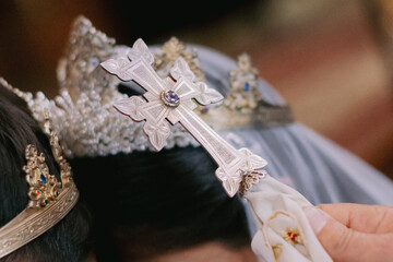 Closeup shot of a silver cross during a traditional Armenian wedding ceremony
