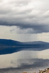 a large body of water with rocks in the foreground