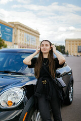 A woman stands near the car.Girl with a auto.Woman driver.Woman auto enthusiast.Driving a car as a...