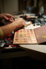 a person working with makeup on a countertop top with a book