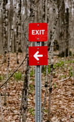 Red exit sign on a trail indicating the correct exit route