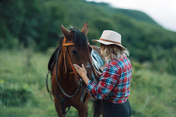 Happy blonde with horse in forest. Woman and a horse walking through the field during the day....