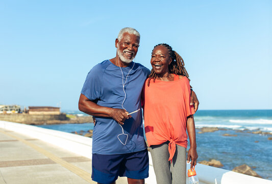 Older couple enjoying a sunny seaside walk together