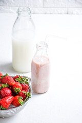 Strawberries, milk jug, and glass on kitchen counter