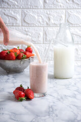Milk into a glass of strawberries