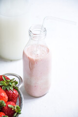 Small jar and metal colander filled with fresh strawberries