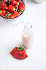 Strawberries in a bowl with a bottle of milk, close-up