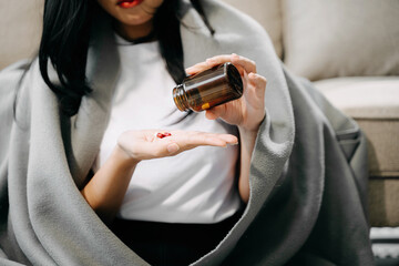 woman holding bottle with pills on hand going to take medicaments prescribed