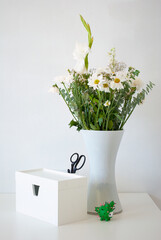 Flower vase on a white table against a white wall