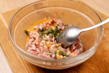 An egg and greens are added to the minced meat. Minced meat for cooking fried meat cutlets.