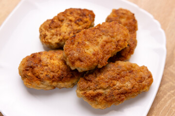 Freshly fried cutlets are placed on a plate.
