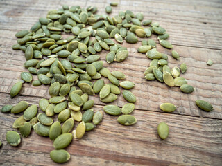 some pumpkin seeds sitting on top of a wooden table as seen in a photograph