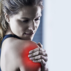 Woman, shoulder and fitness injury with red glow for pain, accident or bruise in workout or exercise at gym. Tired or frustrated female person with sore muscle, ache or inflammation for hurt joint
