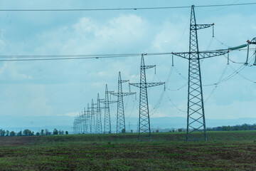 High voltage towers with sky background. Power line support with wires for electricity transmission. High voltage grid tower with wire cable at distribution station. Energy industry, energy saving