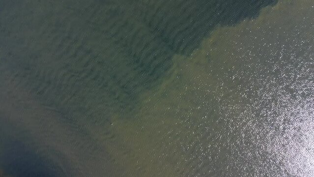 Aerial footage of boats port adjacent a coastal road on a sunny day in Mollosund village in Sweden