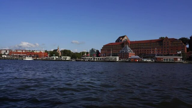 View of the buildings and moored boats on Gota alv River on a sunny day in Gothenburg, Sweden