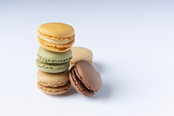 Macarons on a white background close-up. Orange green and brown macaroons. Space for text