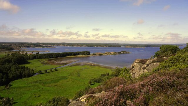Static shot of green fields by the sea on a sunny day in Sweden, Stocken, Mollosund