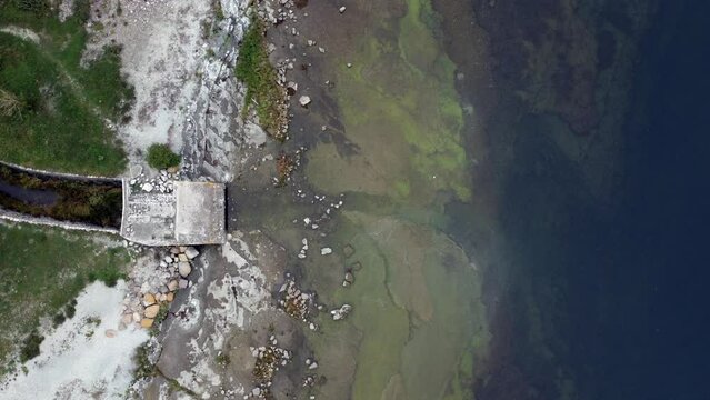 Aerial footage of seascape with a dirty shoreline full of stones in Oland island, Sweden