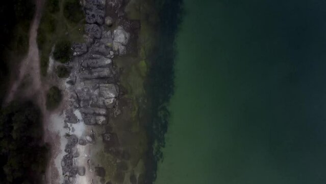 Aerial above the rocky shoreline with coastal houses and clear water of Oland Island in Sweden