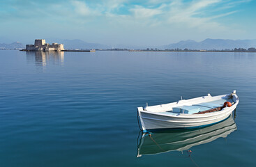 Small fishing boat and Bourtzi fortress in Nafplio, Peloponnese, Greece