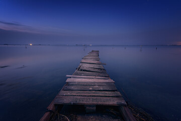 Old wooden walkway used as a pier in the Ebro Delta, Tarragona, just before the sun rises over the...
