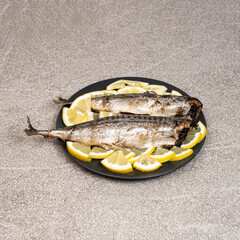 Oven-baked mackerel sea fish dish served with fresh lemon slices