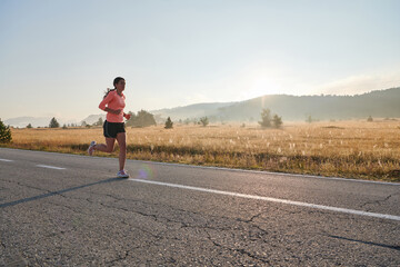 Obraz premium Determined Dawn: Confident and Motivated Athlete Embarks on Sunrise Run.