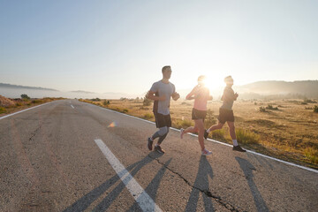 A group of friends, athletes, and joggers embrace the early morning hours as they run through the...