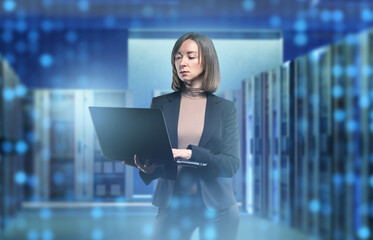 Businesswoman in data center. Woman with laptop near server equipment. System administrator....