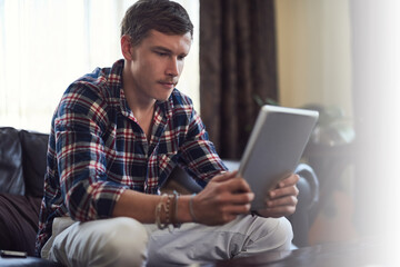 Man, sofa and freelancer with tablet in home, online research and email for information. Male...