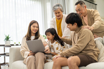 Father and mother with asian kid girl learn on laptop computer reviewing lesson study with online education e-learning.student look for educational knowledge in homeschool at home.Education