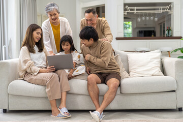 Obraz premium Father and mother with asian kid girl learn on laptop computer reviewing lesson study with online education e-learning.student look for educational knowledge in homeschool at home.Education