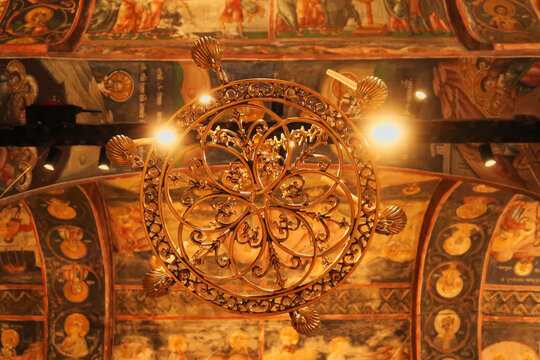 Chandelier inside the Church Complex of the Patriarchate of Pec Monastery, hanging from a ceiling completely covered in colorful paintings, frescos, outside of Peja, Kosovo