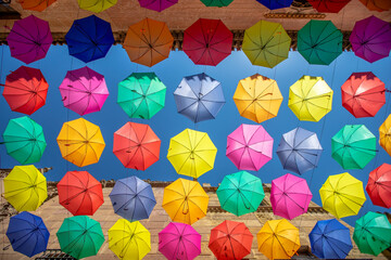 Colorful umbrellas hanging over the street used as decoration in Poble Espanyol in Barcelona