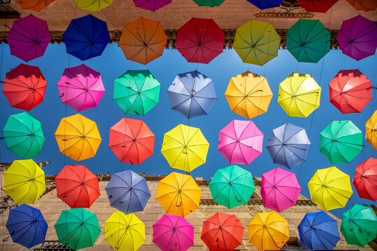 Colorful umbrellas hanging over the street used as decoration in Poble Espanyol in Barcelona