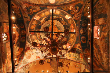 Chandelier hanging from a ceiling completely covered in colorful paintings, frescos inside the Church Complex of the Patriarchate of Pec Monastery, outside of Peja, Kosovo