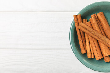 Cinnamon sticks on a textured wooden background. Cinnamon roll. Spicy spice for baking, desserts...