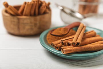 Cinnamon sticks on a textured wooden background. Cinnamon roll. Spicy spice for baking, desserts and drinks. Fragrant ground cinnamon. cinnamon powder Close-up. Place for text. copy space