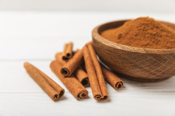 Cinnamon sticks on a textured wooden background. Cinnamon roll. Spicy spice for baking, desserts and drinks. Fragrant ground cinnamon. cinnamon powder Close-up. Place for text. copy space