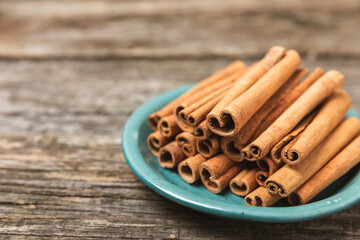 Cinnamon sticks on a textured wooden background. Cinnamon roll. Spicy spice for baking, desserts and drinks. Fragrant ground cinnamon. cinnamon powder Close-up. Place for text. copy space